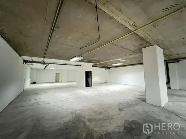Office Space for rent - Expansive open-plan office shell with structural columns and utility conduits.