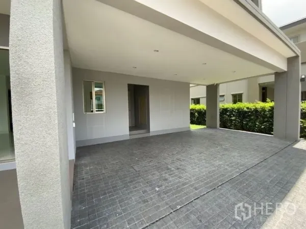 Townhouse for rent in Prawet, Bangkok - Covered two-car carport with tiled driveway beside the main entrance.