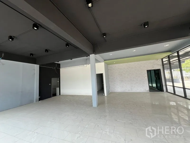 Warehouse for rent in Sam Phran, Nakhon Pathom - Bright showroom or office area with tiled floors and track lighting.