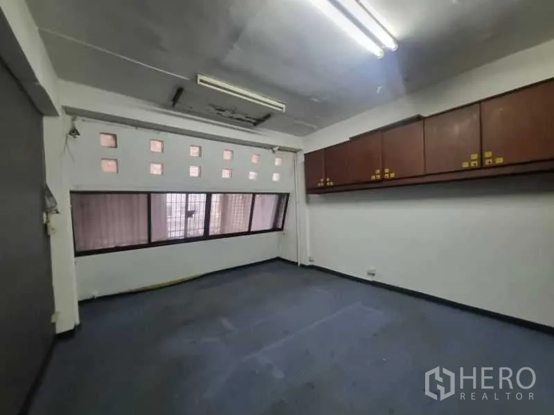 Shophouse for rent in Watthana, Bangkok - Workspace with overhead storage cabinets and horizontal windows.