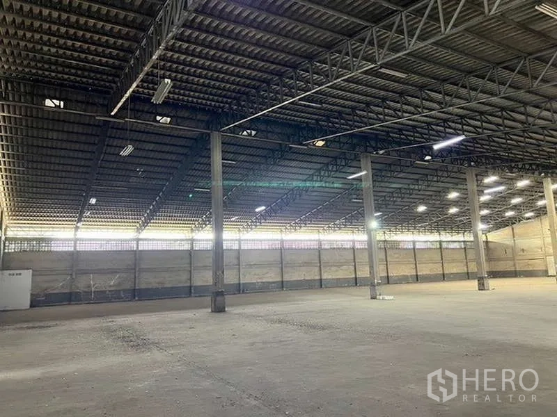 Warehouse for rent - Warehouse interior with ventilated side walls, steel beams and level concrete slab.