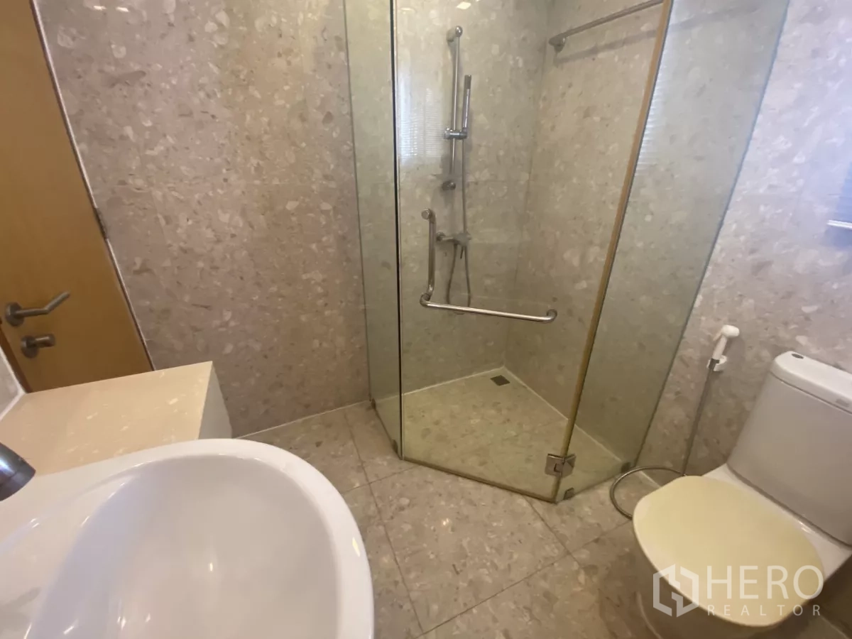 Condominium for rent in Watthana, Bangkok - Close-up of tiled shower with handheld and rain fixtures next to the toilet.