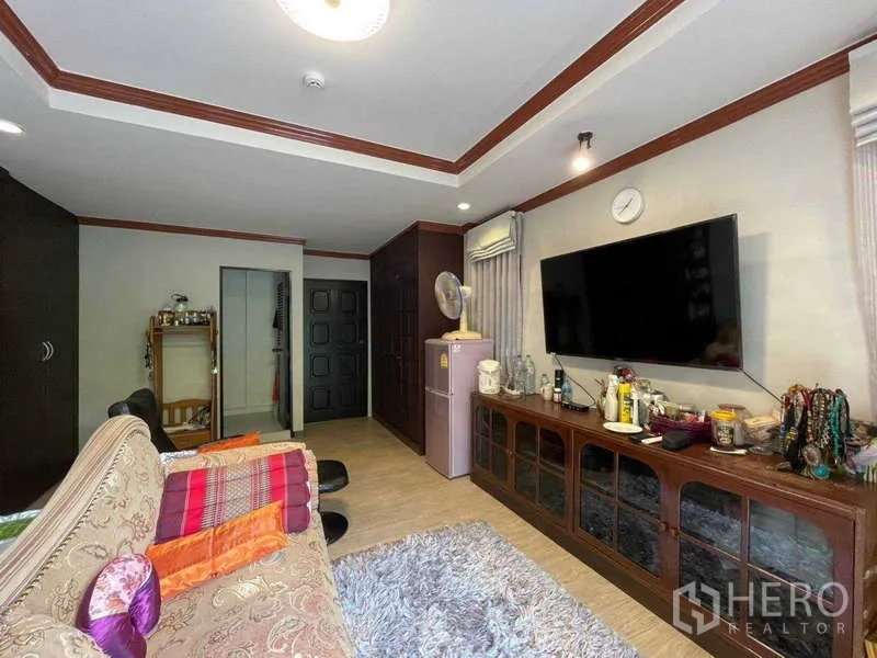 Home Office for rent in Watthana, Bangkok - Media room view with sofa, shag rug and long wooden cabinet storage.