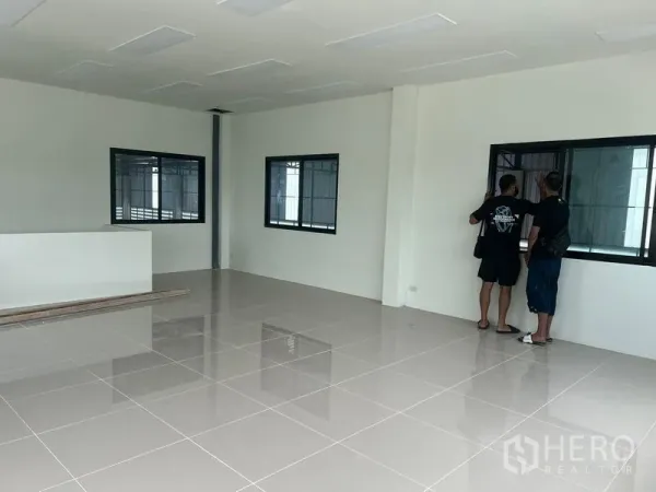 Warehouse for rent in Bang Phli, Samut Prakan - Second‑floor office space with glossy tile flooring and black‑framed windows overlooking the warehouse.