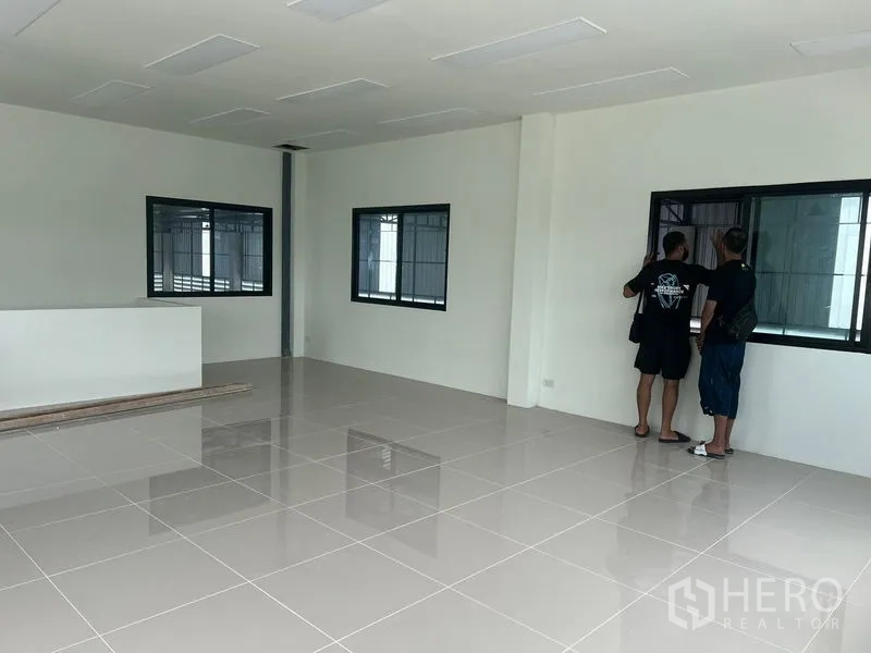 Warehouse for rent in Bang Phli, Samut Prakan - Second‑floor office space with glossy tile flooring and black‑framed windows overlooking the warehouse.