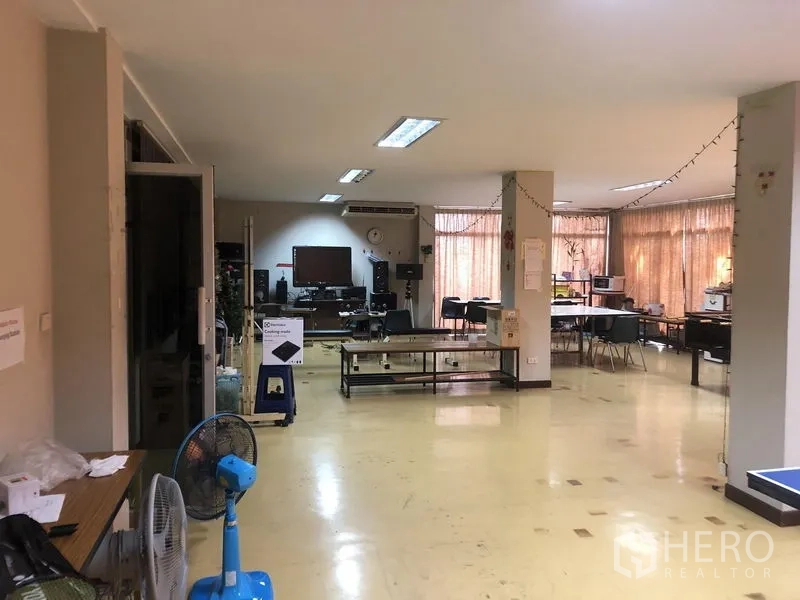 Warehouse for rent in Saphan Sung, Bangkok - Ground-floor office space with desks, windows and fluorescent lighting.