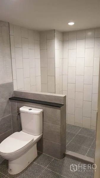 Townhouse for rent or sale in Khlong Toei, Bangkok - Renovated bathroom with walk-in shower and tiled walls.