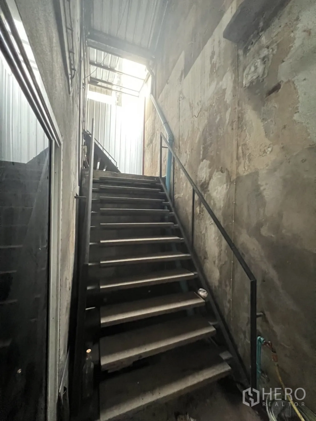 Shophouse for rent in Watthana, Bangkok - Rear entry with covered metal stairs leading to a sliding glass door.