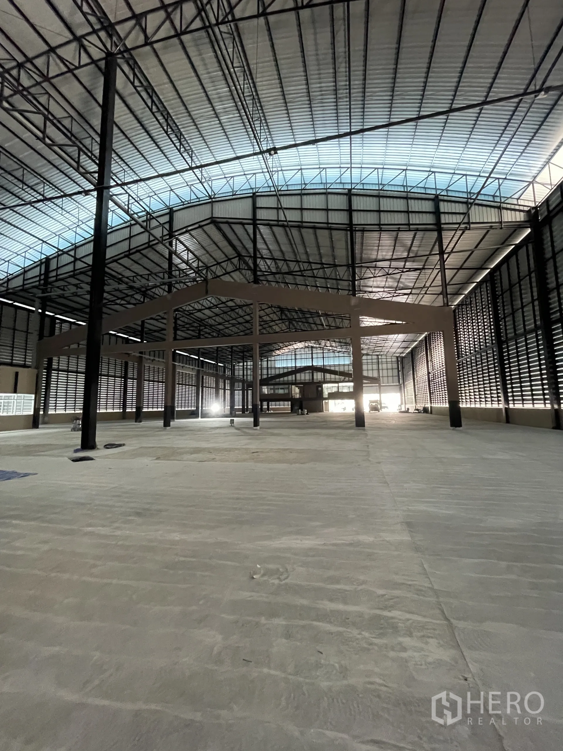 Factory for rent in Chon Buri - Open production floor with reinforced concrete slab and translucent ridge skylight.