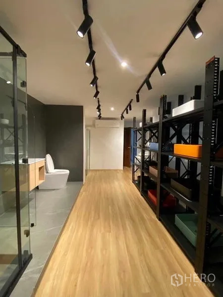 Home Office for rent in Wang Thonglang, Bangkok - Long corridor with track lighting, glass shower area, shelving racks and a toilet