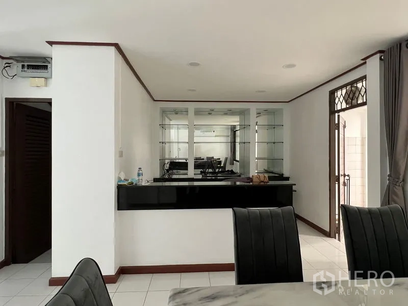 Townhouse for rent in Din Daeng, Bangkok - Bar counter detail with mirrored shelving in the dining area.