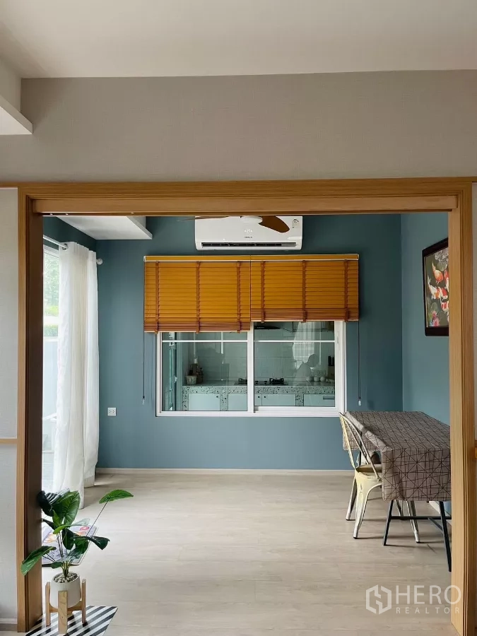 Detached House for rent in Prawet, Bangkok - Versatile dining or family area with blue feature wall and window to Thai kitchen.