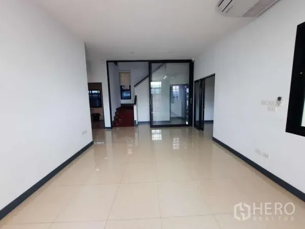 Home Office for rent in Huai Khwang, Bangkok - Open-plan room with glossy tiled floor and a glass partition beside the staircase.