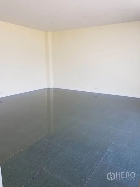 Factory for rent or sale in Mueang Samut Prakan, Samut Prakan - Empty office room with light walls and reflective tiled flooring.