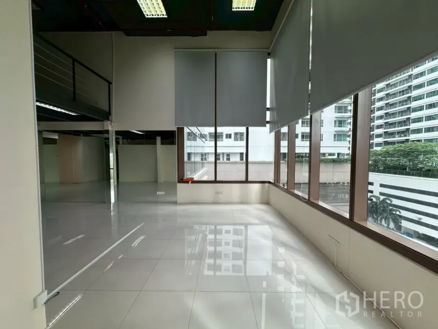 Office Space for rent in Khlong Toei, Bangkok - Sunlit bay of windows facing city buildings, ideal for a breakout or lounge area.