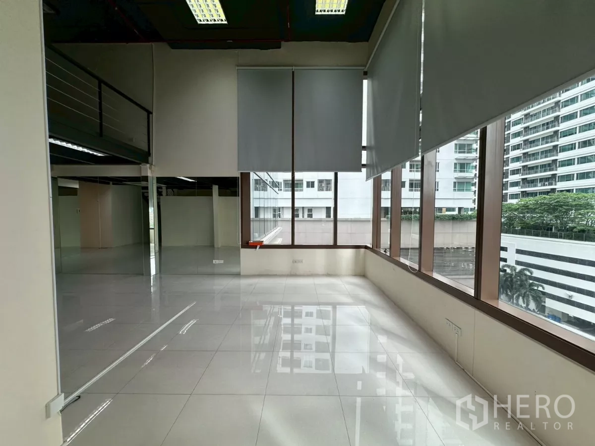 Office Space for rent in Khlong Toei, Bangkok - Sunlit bay of windows facing city buildings, ideal for a breakout or lounge area.
