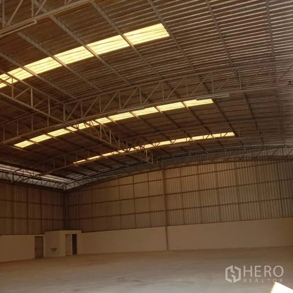 Warehouse for rent in Lat Krabang, Bangkok - Spacious warehouse interior with high steel truss roof, translucent skylight strips and smooth concrete floor.