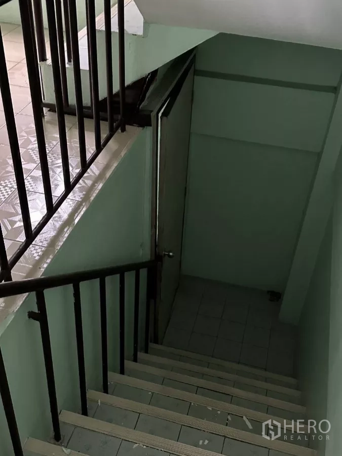 Shophouse for rent in Suan Luang, Bangkok - Interior stairwell with metal handrails and mint-green walls leading to upper floors.