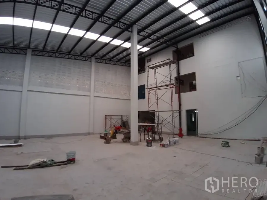 Warehouse for rent in Chatuchak, Bangkok - High‑ceiling warehouse interior with steel truss roof, skylights and concrete floor in Chatuchak, Bangkok.