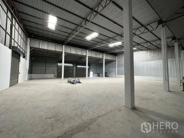 Warehouse for rent in Khlong Luang, Pathum Thani - Wide clear-span interior with steel columns, corrugated walls, and ample floor space.