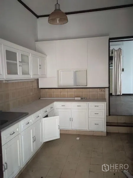 Home Office for rent in Pathum Wan, Bangkok - White L-shaped built-in kitchen with cabinets and tiled backsplash.