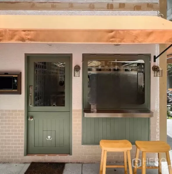 Retail Space for rent in Bang Rak, Bangkok - Shopfront with sage-green door, service window, stainless counter and wooden stools beneath an awning.