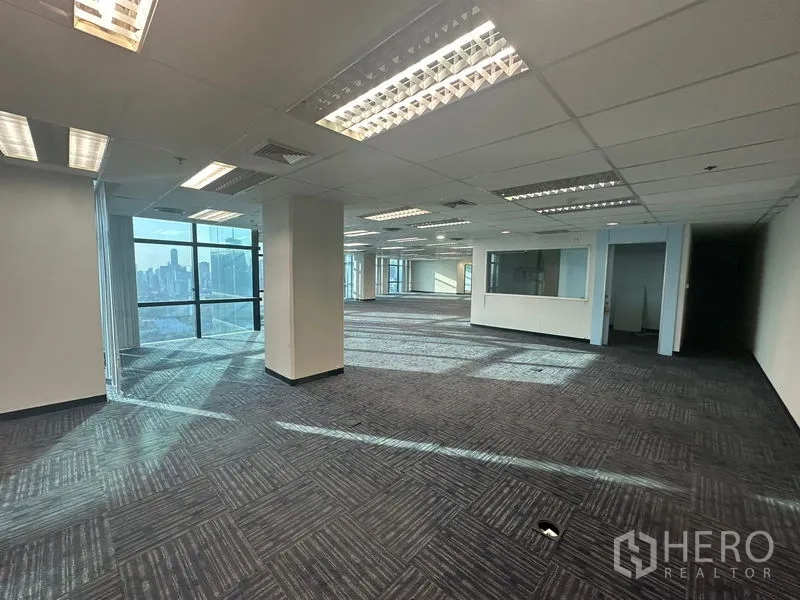 办公空间 出租在Watthana, Bangkok - 宽敞办公楼层，格栅吊顶照明、立柱与内部玻璃隔断。