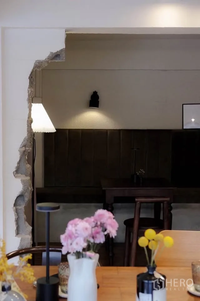 零售空间 for rent in Sathon, Bangkok - 装饰性墙洞框出卡座桌面，前景为摆放花瓶的木台面。