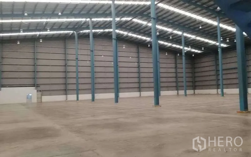 Warehouse for rent in Bang Phli, Samut Prakan - Expansive warehouse interior with high clear height, steel columns, skylights, and polished concrete floor.