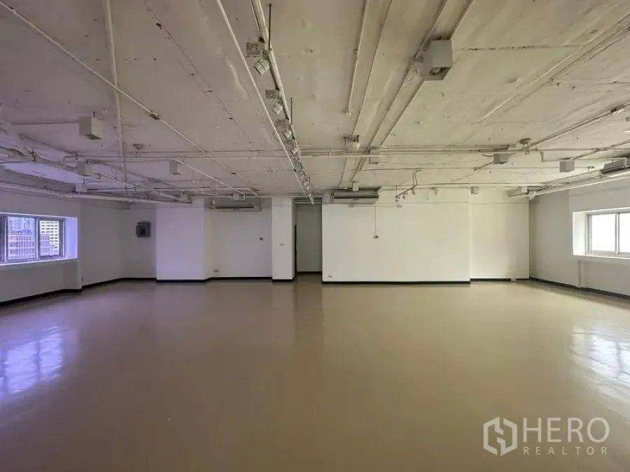 Office Space for rent in Pathum Wan, Bangkok - Large empty office interior featuring track lighting, clean flooring and natural light from dual-aspect windows.