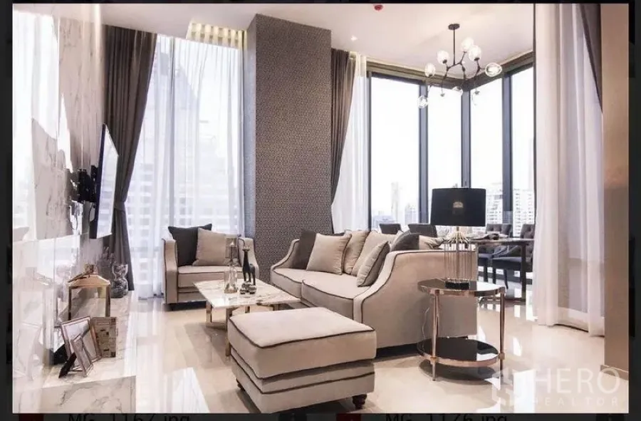 公寓 出租在Bang Rak, Bangkok - 宽敞起居区，转角沙发与亮面地坪，环幕窗连接用餐角落。