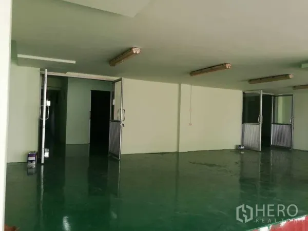 工厂 出租在Mueang Samut Sakhon, Samut Sakhon - 一层工作区，配多扇金属玻璃门和日光灯照明。