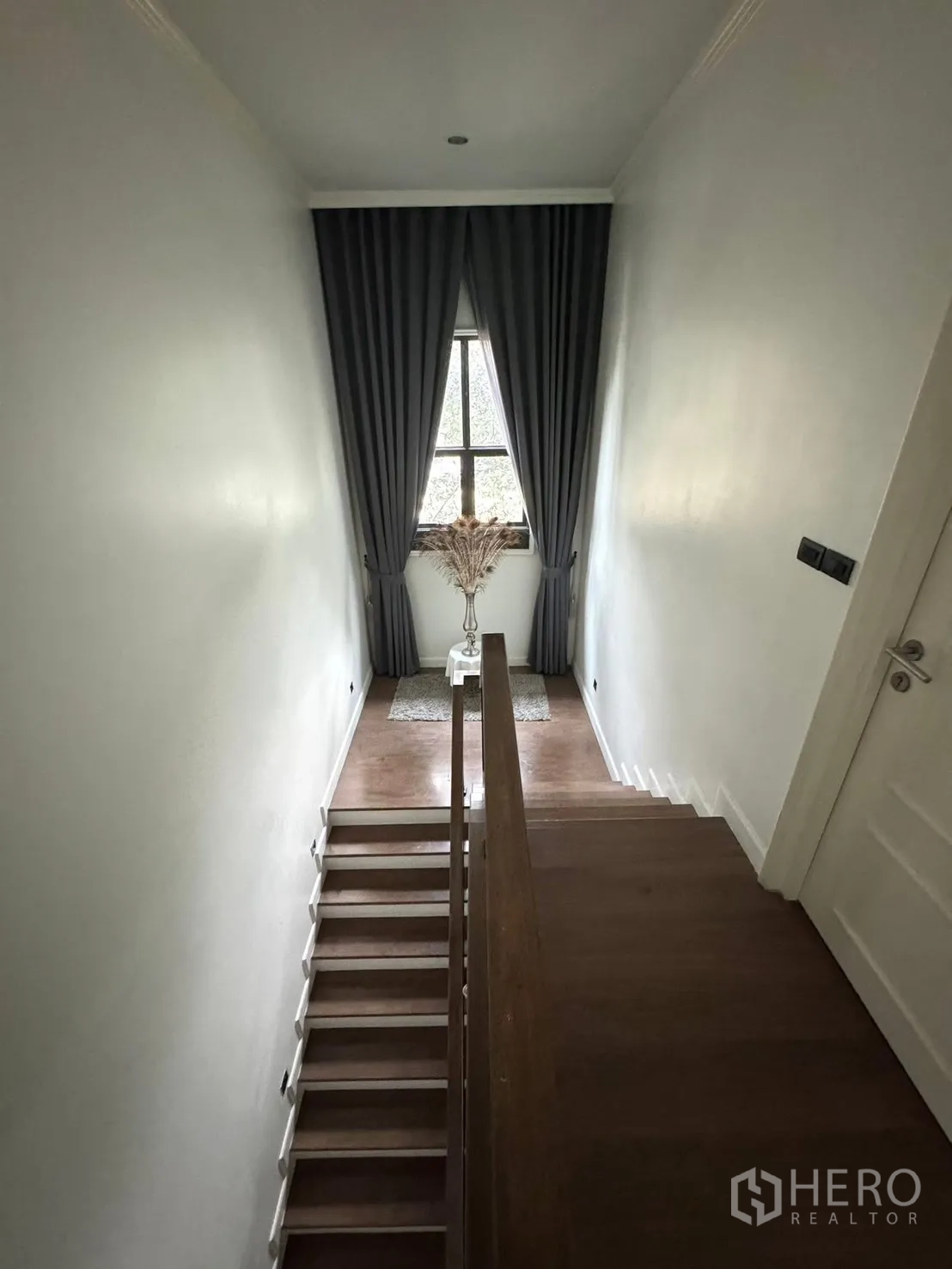 Detached House for sale in Mueang Pathum Thani, Pathum Thani - Stair landing with window, long drapes and wooden flooring.