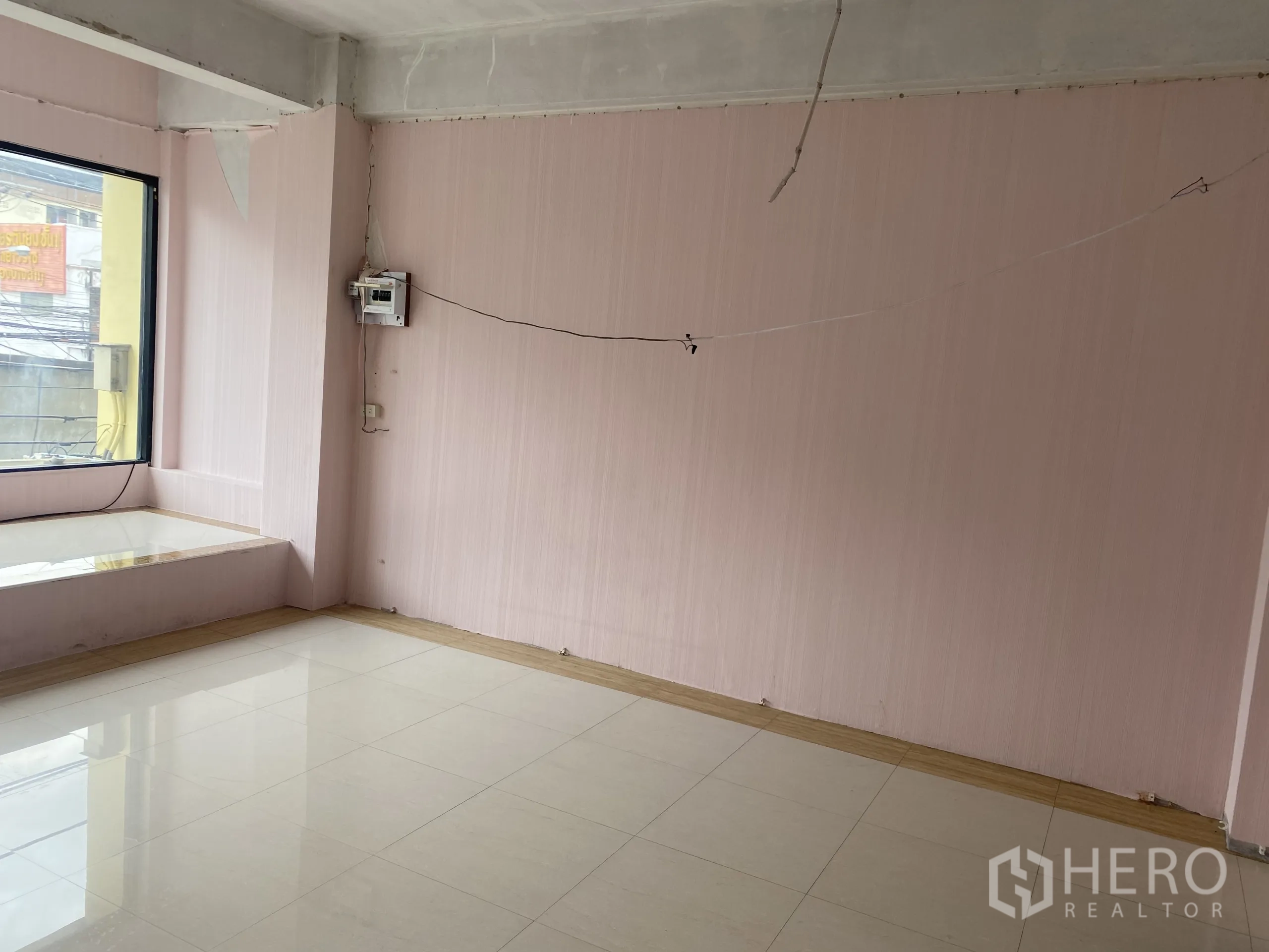 店屋 出租在Khlong Toei, Bangkok - 角间房带粉色墙面、大窗台与浅色地砖。