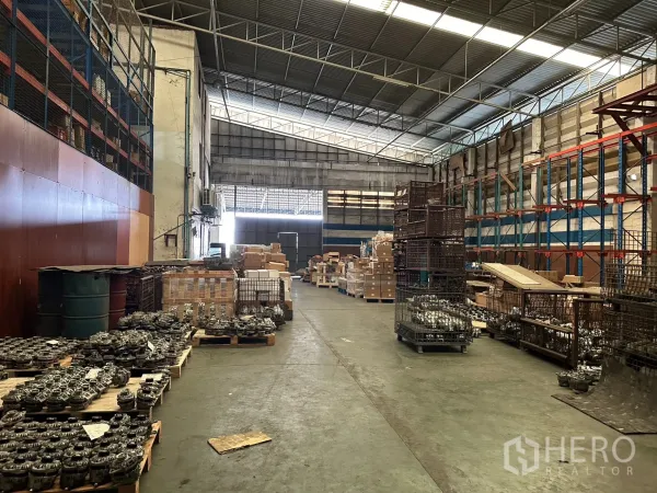 Factory for rent in Lam Luk Ka, Pathum Thani - Factory interior showing shelving, crates and a wide loading corridor.