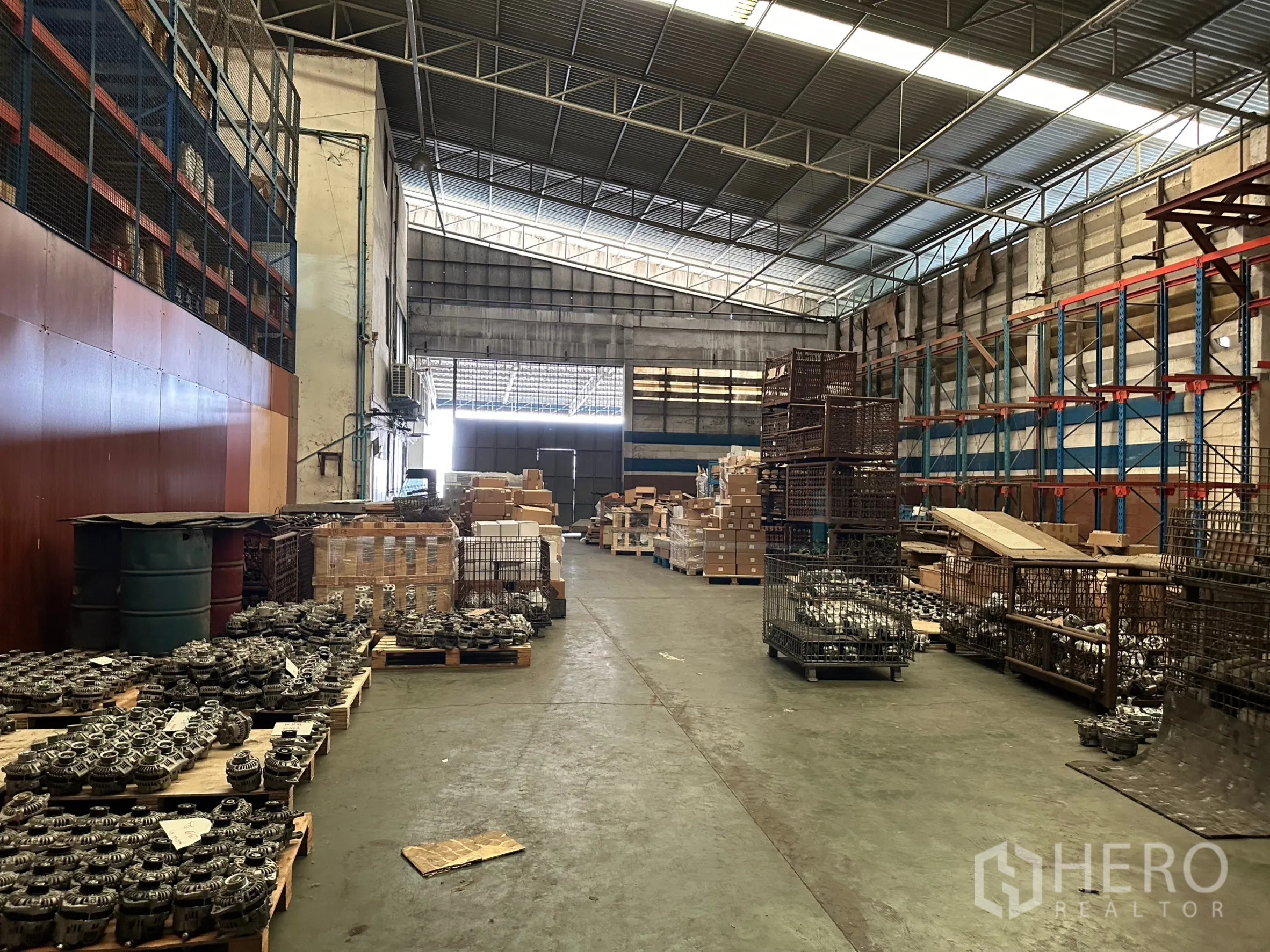 Factory for rent in Lam Luk Ka, Pathum Thani - Factory interior showing shelving, crates and a wide loading corridor.