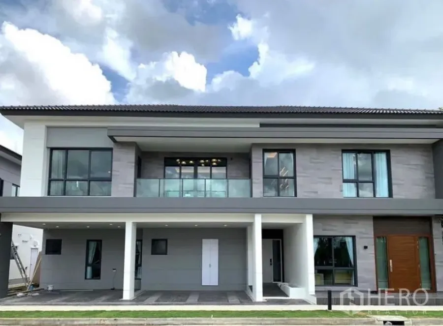 独立式住宅 出售在Bang Phli, Samut Prakan - 现代两层外立面，设阳台、大窗与有顶车位。