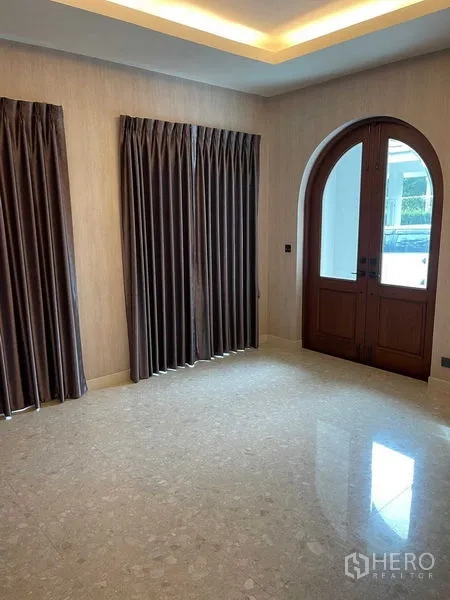 Detached House for sale in Mueang Samut Prakan, Samut Prakan - Foyer with arched wooden double door and full-length curtains.