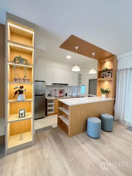 Townhouse for rent in Prawet, Bangkok - Modern kitchen with white cabinetry, island with pendant lights, open shelving and stainless refrigerator.
