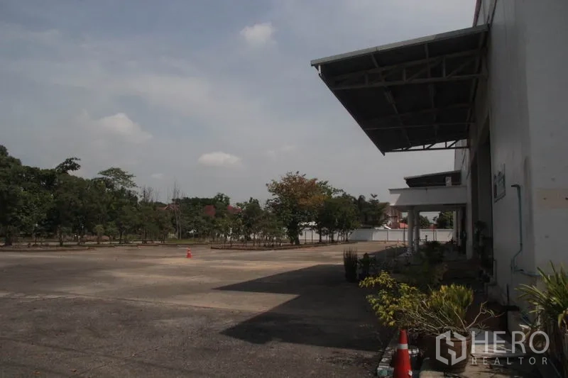 Warehouse for rent in Lam Luk Ka, Pathum Thani - Paved forecourt beside the warehouse with canopy and greenery for efficient circulation.