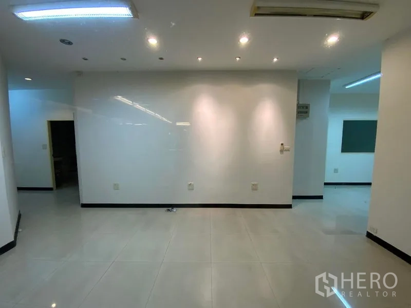 办公空间 出租在Watthana, Bangkok - 开放式工作区，白色墙面配射灯与大块瓷砖地面