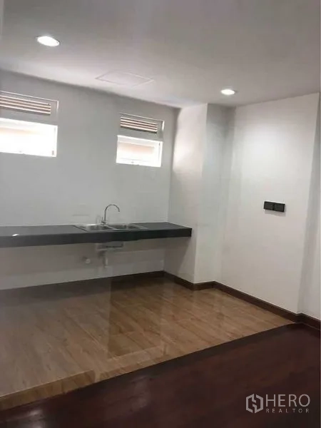 Shophouse for rent in Bang Rak, Bangkok - Compact pantry with sink and countertop, ceiling lights and wood-look flooring.