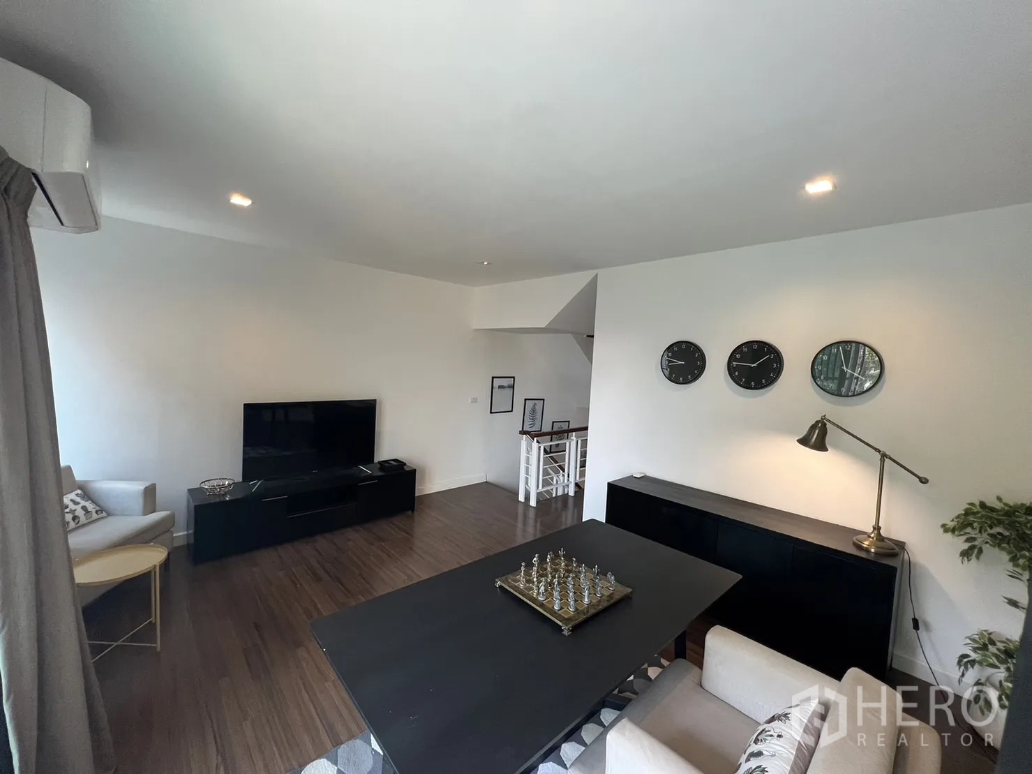 联排别墅 for rent in Suan Luang, Bangkok - 二楼起居/书房，电视柜、桌子与木纹地板。