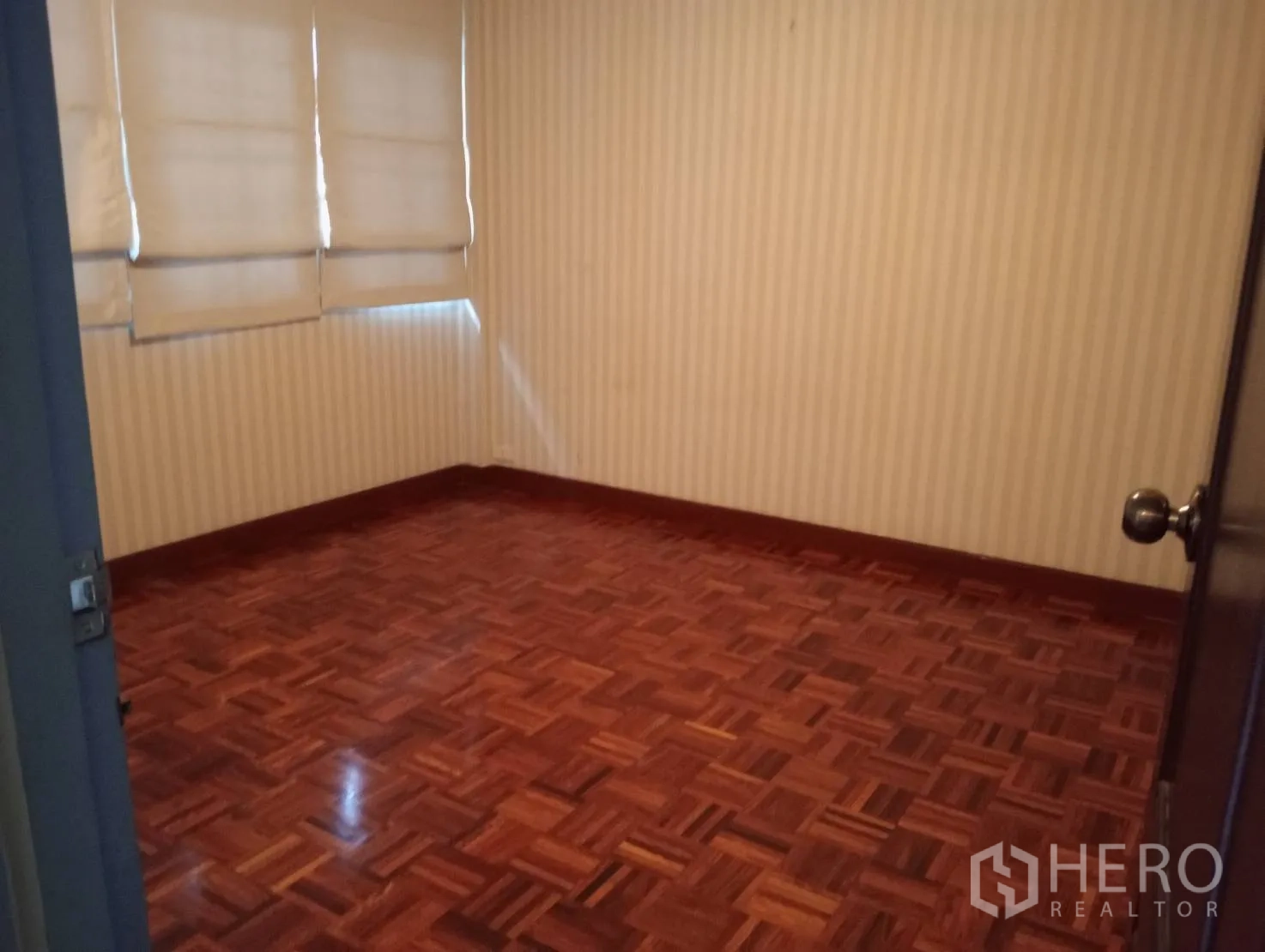 Home Office for rent in Khlong Toei, Bangkok - Bedroom with parquet flooring and window blinds.