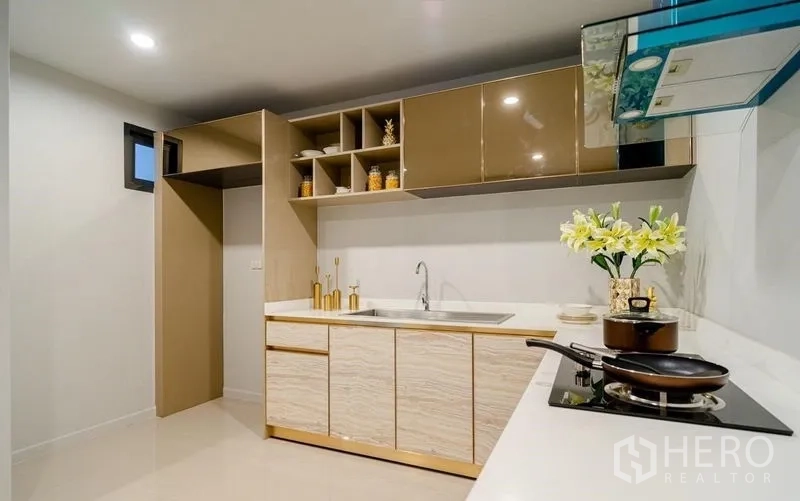 Detached House for sale in Lam Luk Ka, Pathum Thani - Fitted L-shaped kitchen with hob, hood and ample storage.