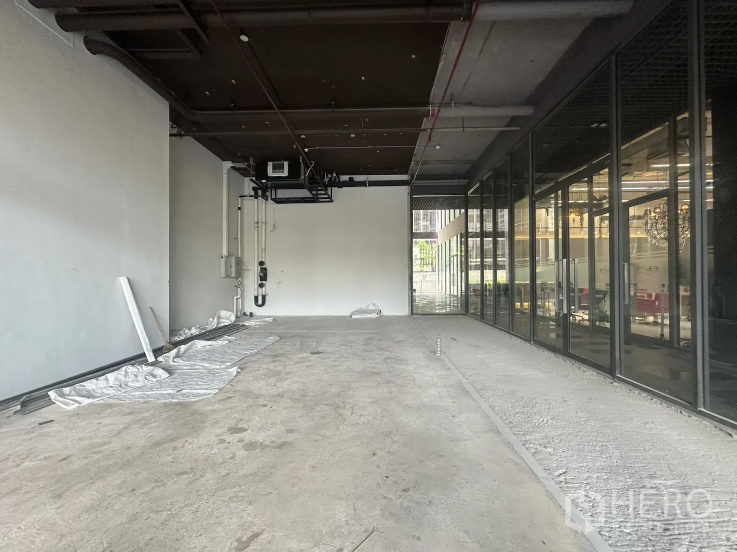 零售空间 for rent in Khlong Toei, Bangkok - 高挑外露顶面，管道与侧面玻璃引入自然采光。