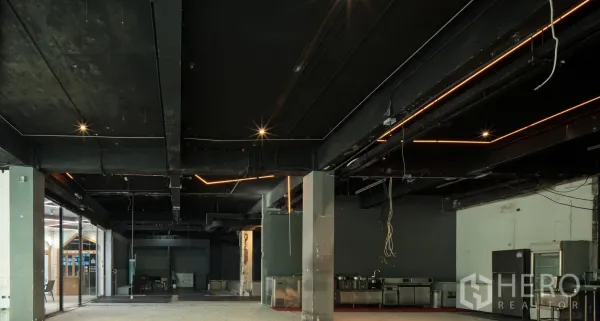 Retail Space for rent in Watthana, Bangkok - Open-plan floor with industrial ceiling, linear lights and stainless kitchen equipment.