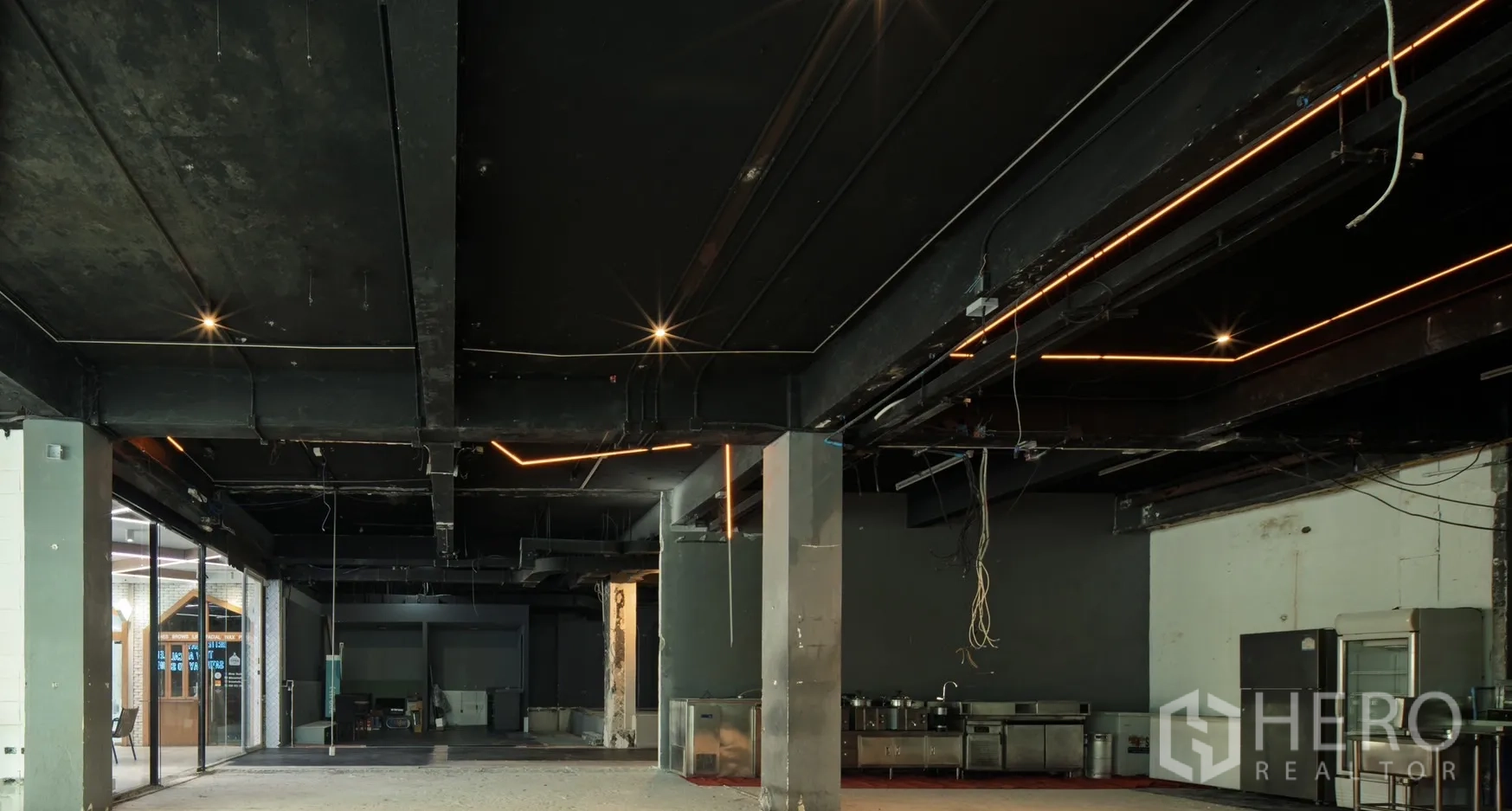 Retail Space for rent in Watthana, Bangkok - Open-plan floor with industrial ceiling, linear lights and stainless kitchen equipment.
