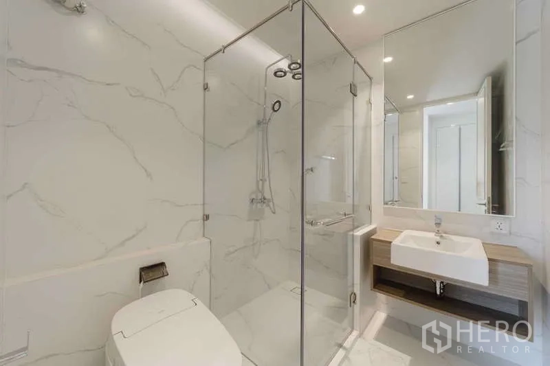 Townhouse for rent or sale in Watthana, Bangkok - Bright bathroom featuring a glass-enclosed shower, smart toilet, and wall-mounted vanity.