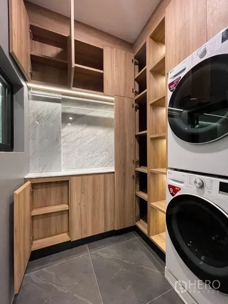 Townhouse for sale - Laundry room featuring stacked washer and dryer with custom wood cabinetry and shelving.